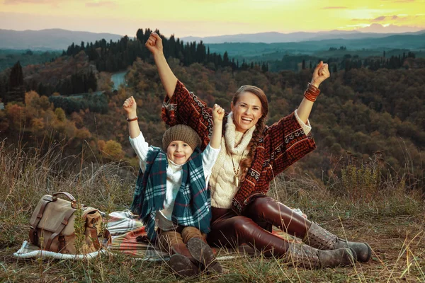 Matka a dítě turisty radují, zatímco sedí na dece — Stock fotografie