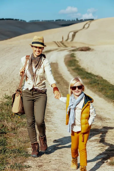 Lachende jonge moeder en kind wandelaars genieten van promenade — Stockfoto