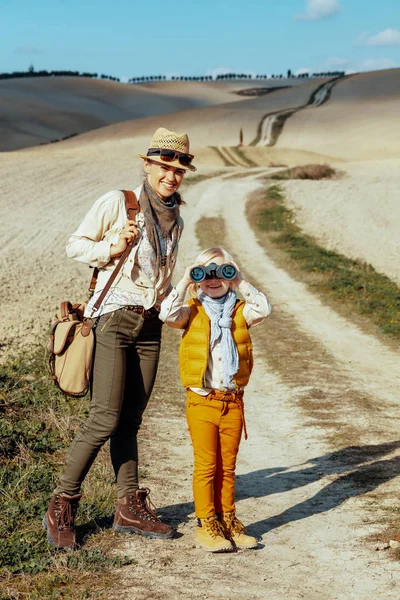 Sorrindo mãe e filha olhando i câmera através de binóculos — Fotografia de Stock