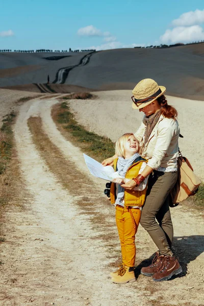 Sonriente madre moderna y niños excursionistas con mapa — Foto de Stock