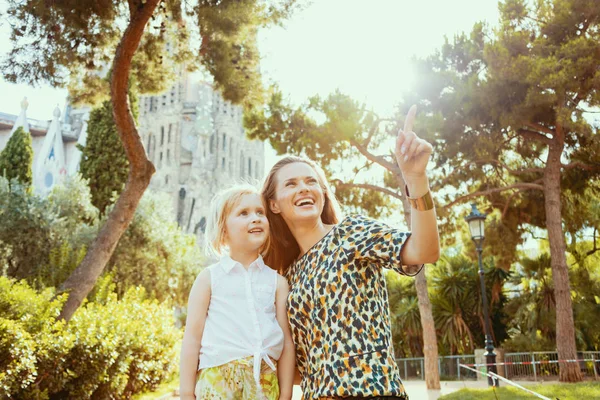 Smiling mother and daughter travellers pointing at something — Stock Photo, Image