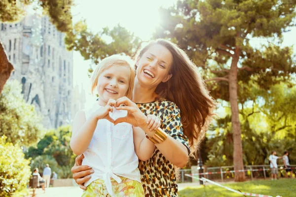 Mother and daughter travellers showing heart shaped hands — Stock Photo, Image