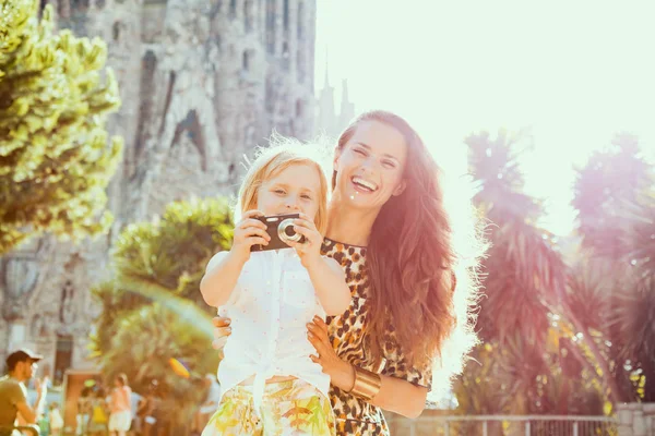 Smiling stylish mother and daughter taking photo with camera — Stock Photo, Image