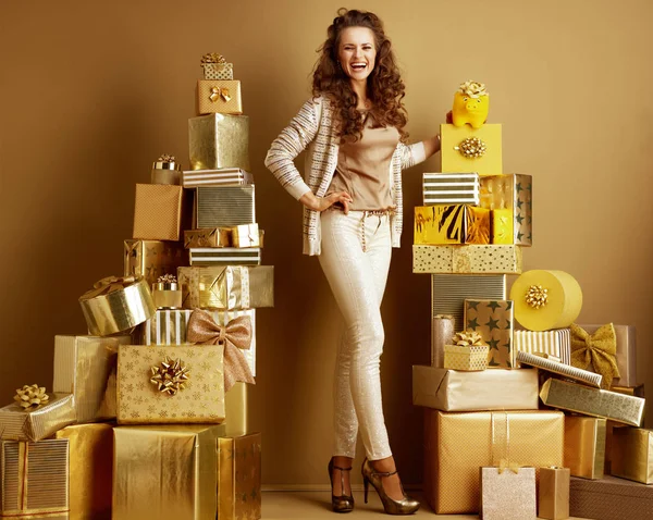 Mosolyogva elegáns nő mutatja a sárga piggy bank a arany-íj — Stock Fotó