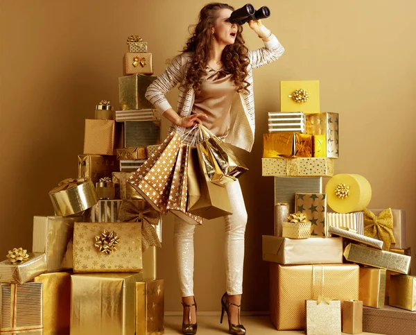 Stylish shopper woman shopper looking aside through binoculars — Stock Photo, Image