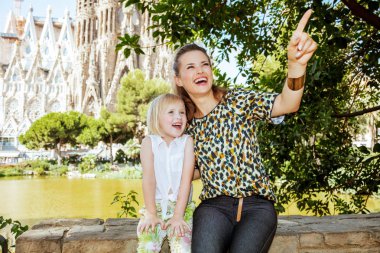 mutlu zarif anne ve kızı bir şeye işaret