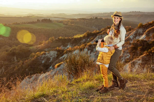 Mother and child tourists looking into the distance through bino — Stock Photo, Image