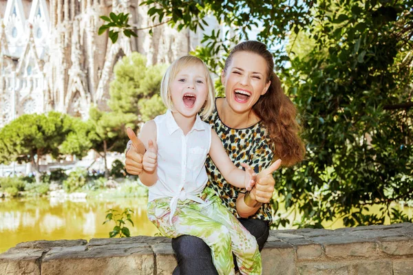 Lachende elegante moeder en dochter toeristen duimen opdagen — Stockfoto