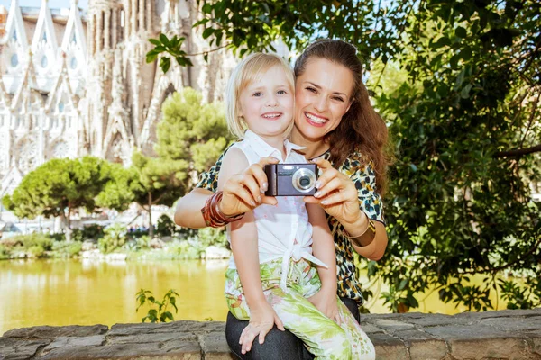 Moeder en kind toeristen nemen van foto met camera glimlachen — Stockfoto