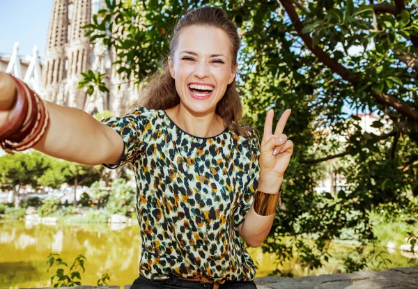 Selfie を取ると勝利を示す幸せなエレガントな旅行者女性 — ストック写真