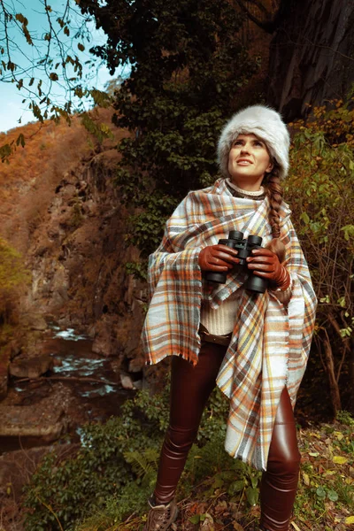 Kvinna hiker med kikare undersöker distans i skogen — Stockfoto