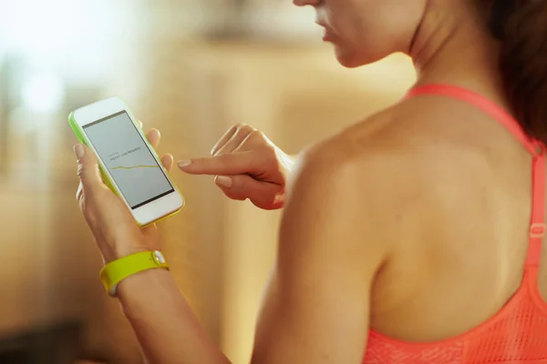 Primer plano en la pantalla del teléfono inteligente con aplicación de fitness en la mano de la mujer — Foto de Stock