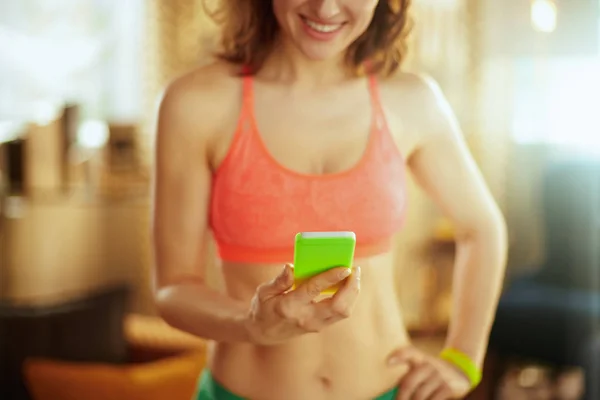 Closeup on smartphone in hand of fit woman using smartphone app — Stock Photo, Image