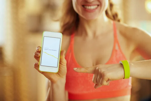 Primer plano en la pantalla del teléfono con la aplicación en forma en la mano de la mujer feliz ajuste — Foto de Stock