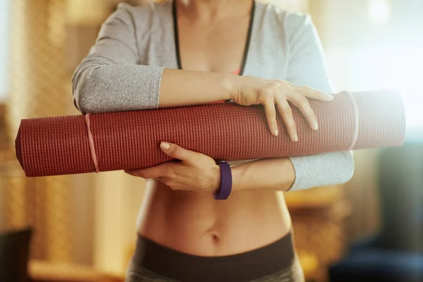 Close-up no tapete de fitness em mãos de mulher em forma em casa moderna — Fotografia de Stock