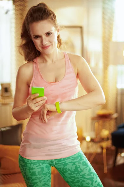 Mujer comprobar los datos de rastreador de fitness en la aplicación de teléfono inteligente —  Fotos de Stock