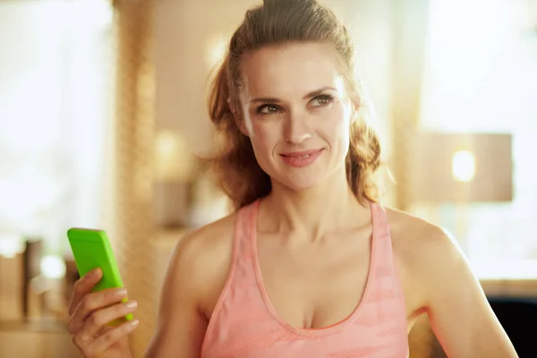 Женщина со смартфоном для отслеживания сердечного ритма в фитнес-приложении — стоковое фото