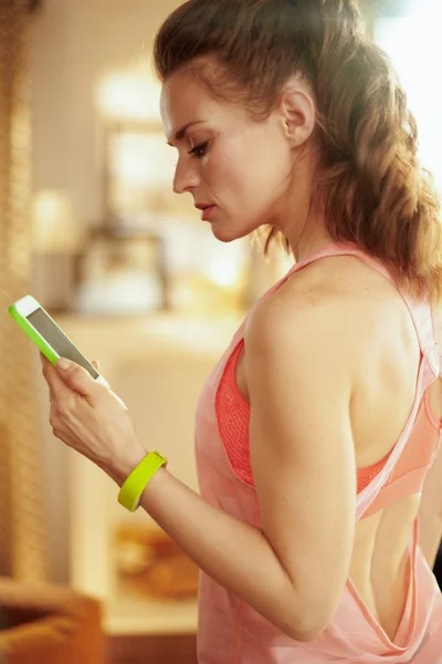 Τακτοποίηση γυναίκα με smartphone χρησιμοποιώντας το app να παρακολουθείτε τη δραστηριότητα γυμναστήριο — Φωτογραφία Αρχείου