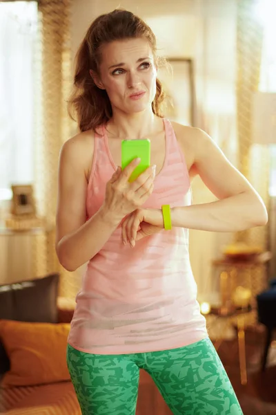 Donna che controlla i dati dal fitness tracker in un'app per smartphone — Foto Stock