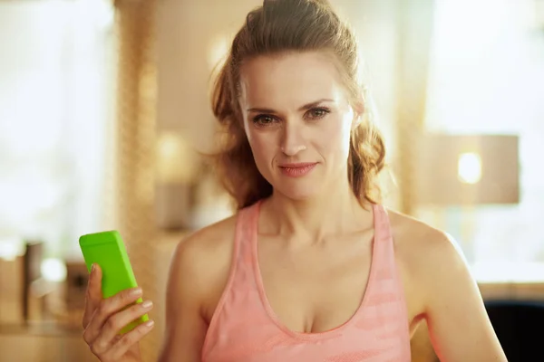 Sports woman with smartphone to track steps in fitness app — Stock Photo, Image