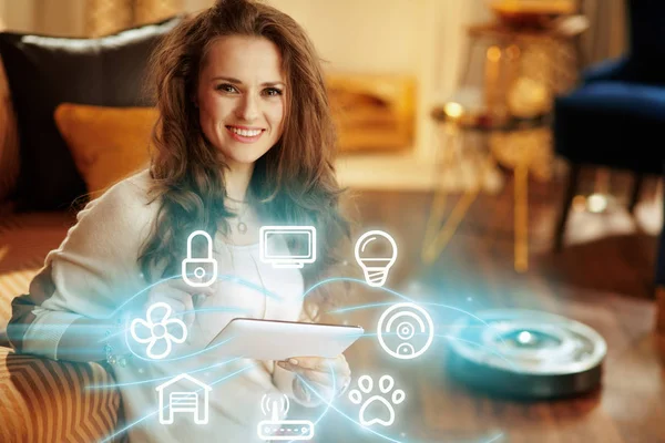 Woman using smart home application on tablet PC and robot vacuum — Stock Photo, Image