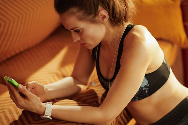 Nachdenklich Fitte Sportlerin Fitnessbekleidung Modernen Haus Mit Online Fitnesstrainingsprogramm Smartphone — Stockfoto