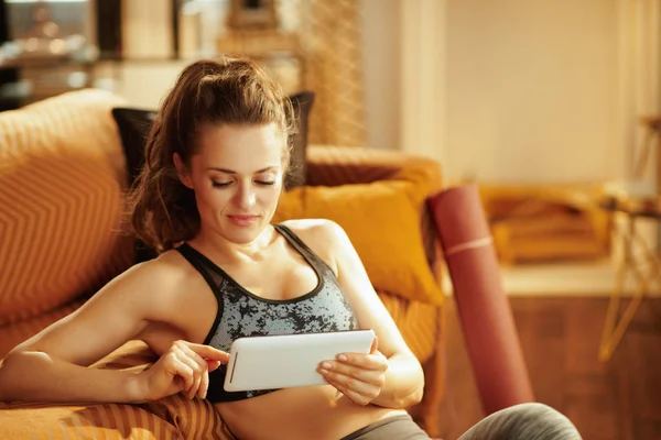 Entspannte Gesunde Frau Fitnessbekleidung Modernen Wohnzimmer Mit Tablet Trainingsergebnisse Den — Stockfoto