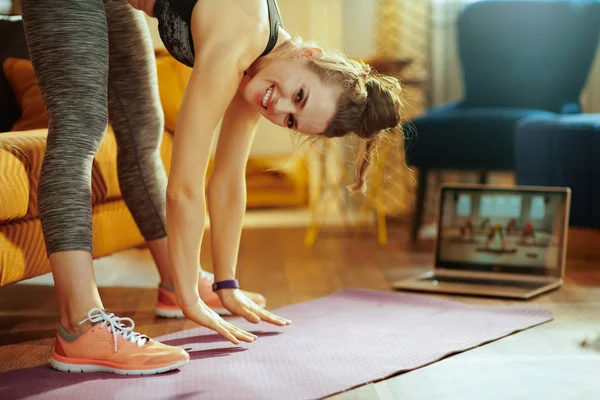 Uśmiechnięta Młoda Kobieta Sportowa Odzieży Sportowej Nowoczesnym Domu Pomocą Laptopa — Zdjęcie stockowe