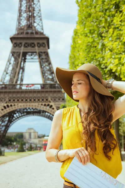 放松时尚旅行妇女黄色上衣和帽子与地图在Champ Mars俯瞰埃菲尔铁塔在巴黎 — 图库照片