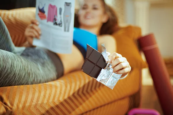 Närbild Chokladkaka Händerna Fit Kvinna Soffan Med Tidningen Det Moderna — Stockfoto