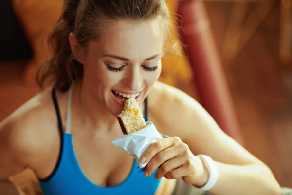 Feliz Mujer Activa Ropa Fitness Casa Moderna Morder Barra Energía —  Fotos de Stock