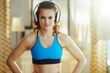 modern oturma odasında kulaklıkla müzik dinleyen kadın