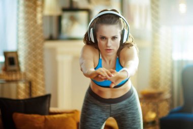 Modern bir evde, kulaklık takan genç bir kadın.