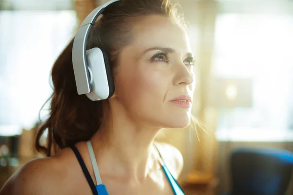 Mujer activa escuchando música con auriculares en el hogar moderno —  Fotos de Stock