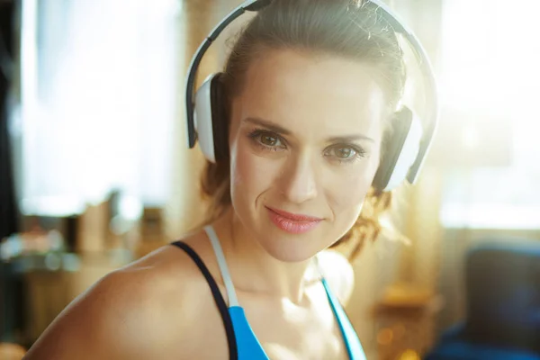 Actieve vrouw die naar muziek luistert met een koptelefoon bij Modern Home — Stockfoto