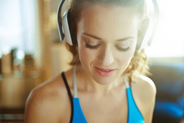Actieve vrouw die naar muziek luistert met een koptelefoon bij Modern Home — Stockfoto