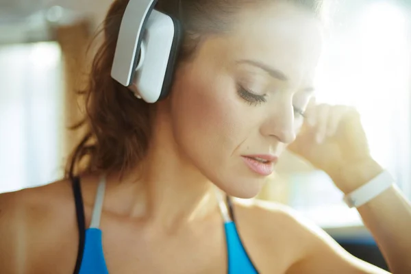 Женщина слушает музыку с наушниками в современной гостиной — стоковое фото