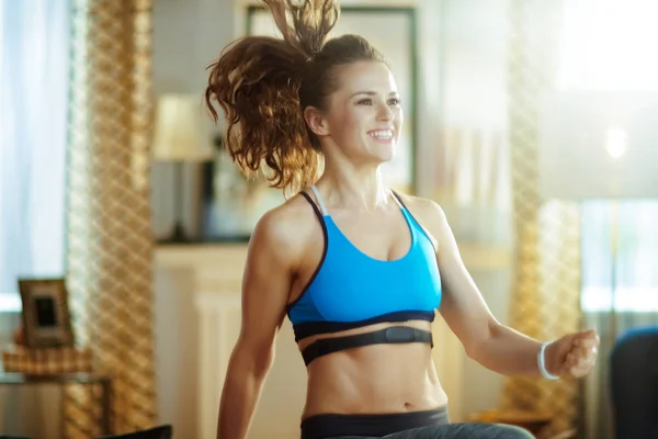 Gülümseyen genç spor kadın egzersiz ve kalp hızı monitörü kullanarak — Stok fotoğraf