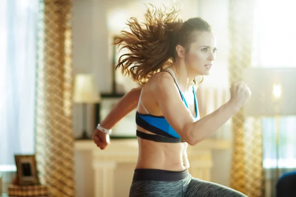 Gezonde vrouw in fitness kleding in modern huis workout — Stockfoto