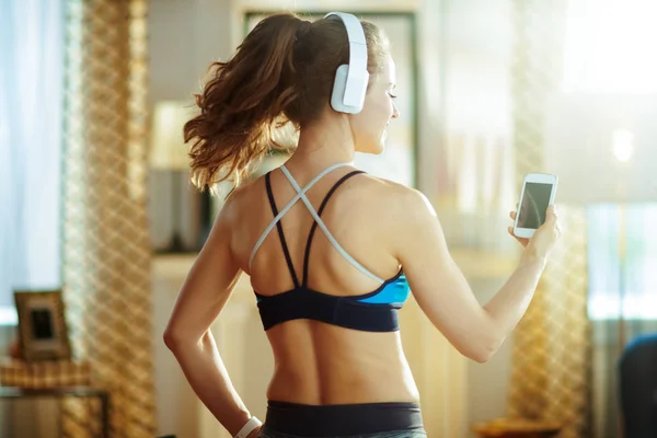 Woman in headphones using app to track fitness activity — Stock Photo, Image