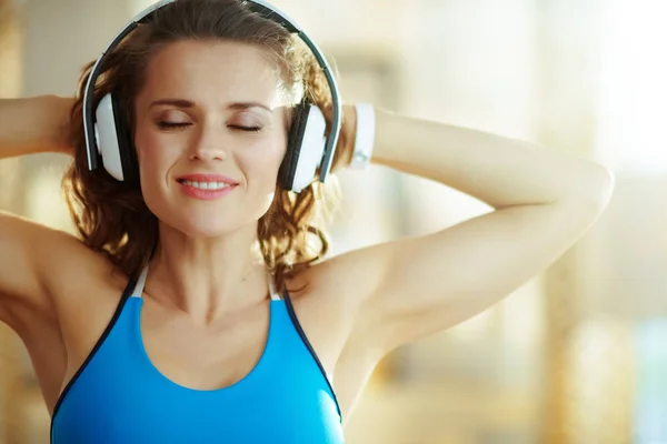 Mujer escuchando música con auriculares en la sala de estar moderna —  Fotos de Stock