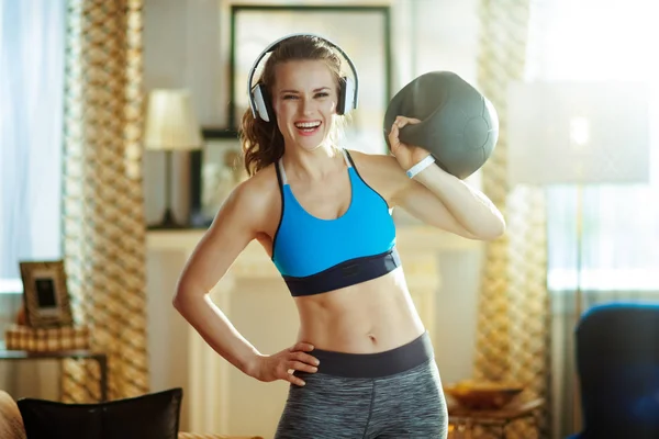 Femme active heureuse dans les écouteurs avec équipement d'entraînement fonctionnel — Photo