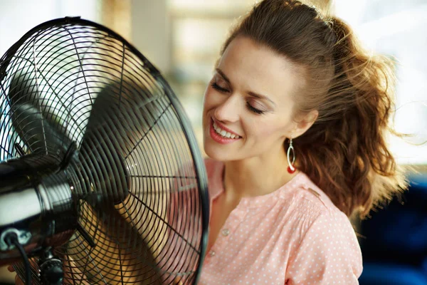 Gülümseyen şık ev hanımı fan önünde soğuyor — Stok fotoğraf