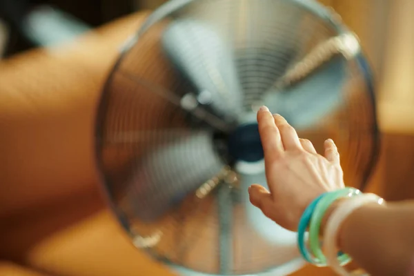 Mão feminina esticando-se para ventilador de pé chão elétrico — Fotografia de Stock