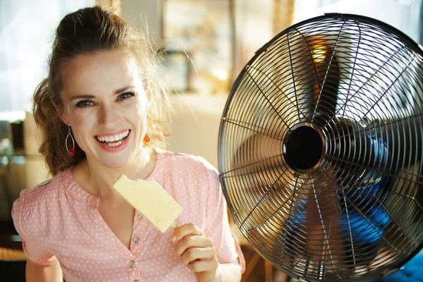 Gelukkig stijlvolle vrouw met ijs afkoelen in de voorkant van de ventilator — Stockfoto