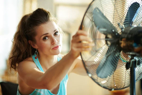 Vrouw genieten van frisse lucht in de voorkant van werkende ventilator — Stockfoto