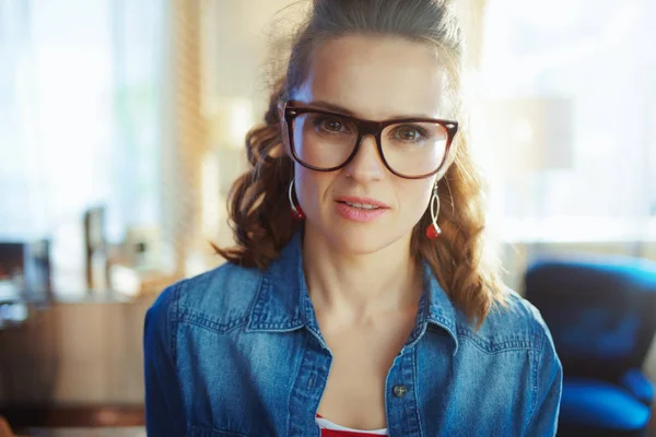 Jonge vrouw in moderne woonkamer in zonnige zomerdag — Stockfoto