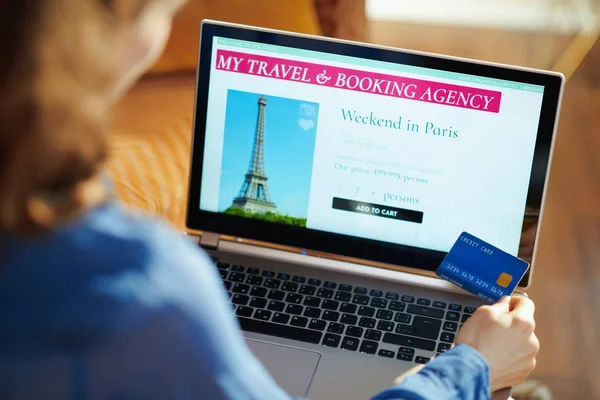 Женщина с сайтом путешествий на ноутбуке с голубой кредитной картой — стоковое фото