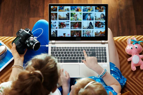 Mother and child looks at photo collage on laptop — Stock Photo, Image