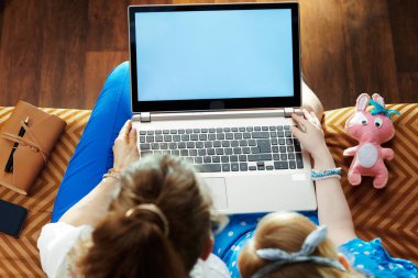 modern anne ve kızı dizüstü bilgisayarda boş ekran bakıyor